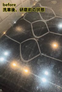 秋田でスポット照明で光を当てたトヨタ202ブラックのボンネット。洗車傷と水シミがはっきり見える状態。